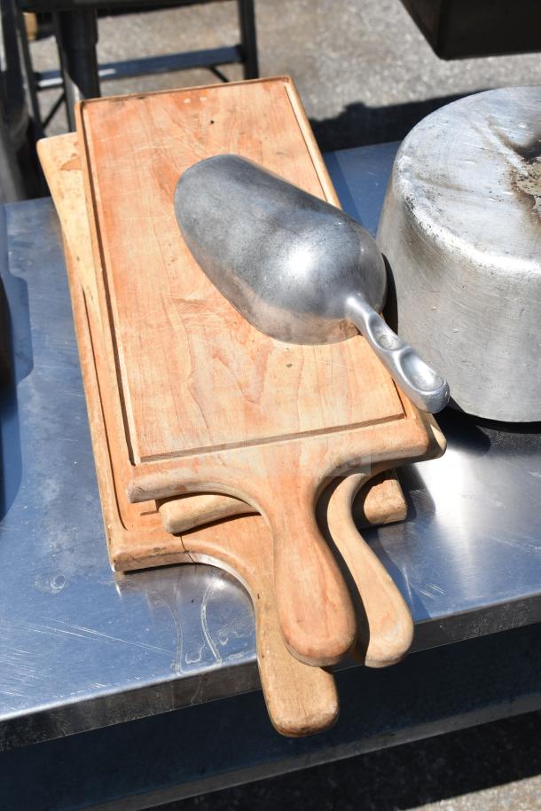 Commercial table with under shelf; includes wood cutting boards, metal scoop, and pot. Ideal for kitchen use.
