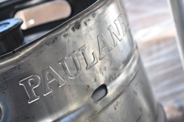 Commercial table with under shelf, including several kegs. "Paulaner" marked on keg. Does not include sink. Good condition.
