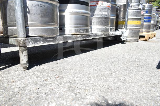 Commercial table with under shelf, includes multiple kegs on top. Metal legs and surface, no visible damage. No sink included.