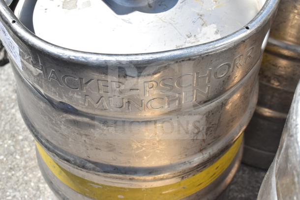 Multiple half-size metal barrel kegs, engraved with "Hacker-Pschorr München," showing signs of wear.