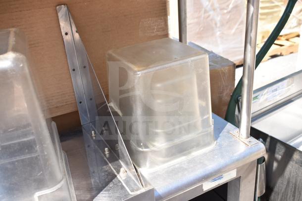 Commercial table with 2-tier over shelf, under shelf, and clear container contents, stainless steel, minor wear.