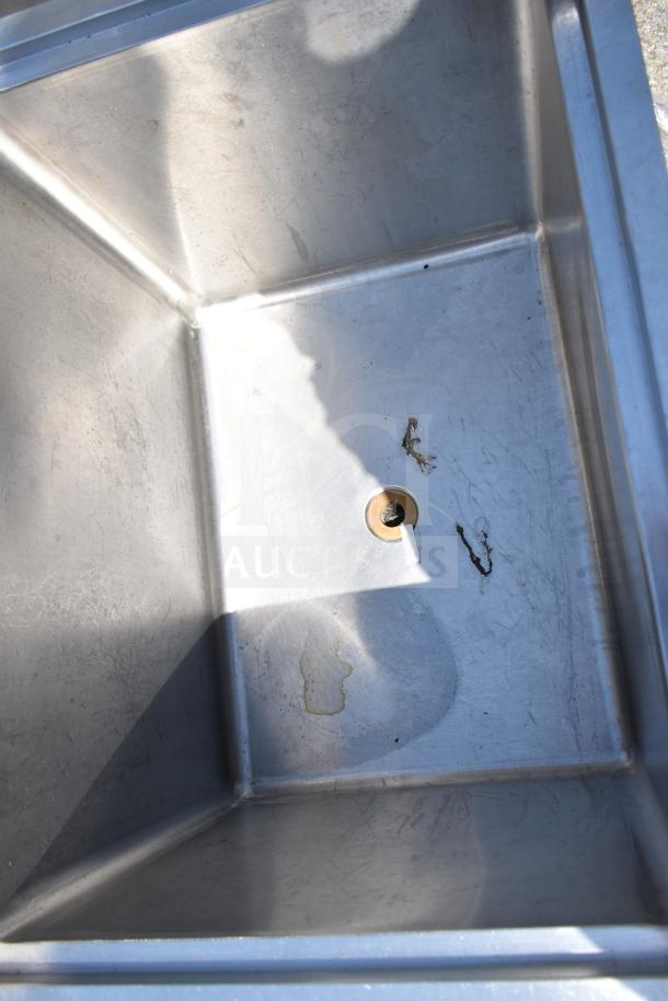 Stainless steel commercial ice bin with drain, showing signs of wear and rust. Perfect for restaurant use.