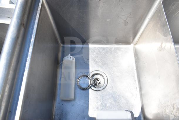 Commercial 3 bay sink with stainless steel construction and integrated drain. Visible bottle with "STEAK" label.