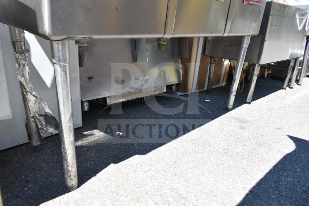 Commercial 3 bay sink with stainless steel construction and sturdy legs. Some wear visible. Ideal for restaurant use.