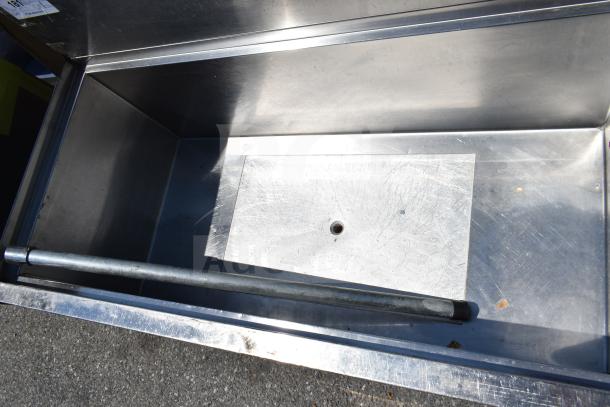 Commercial stainless steel ice bin with cold plate, features durable construction and visible interior drain hole, good condition.