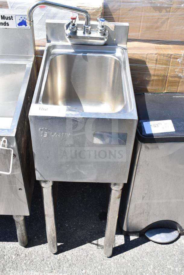 Commercial single bay sink with dual faucet, stainless steel, embossed with "L&JNY," showing light wear, on sturdy legs.