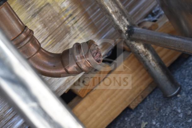 Commercial single bay sink piping and frame. Copper pipe detail and sturdy metal legs. Visible wear and industrial style.