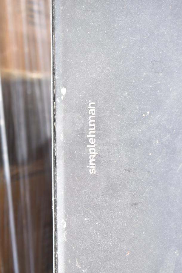 Simplehuman metal foot pedal trash can with visible branding. Slight wear on surface. Auction bid doubles quantity.