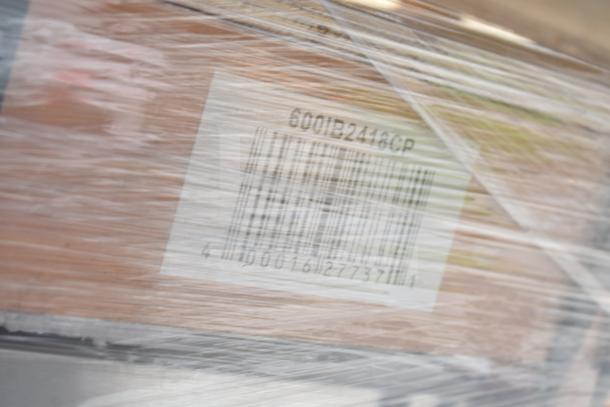 Three brand new items including an ice bin and wire shelves, wrapped with visible barcode label, sold as scratch and dent.