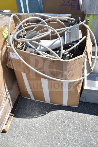 Cardboard box filled with various cables and metal fixtures. Box shows wear. Label marked "188". Miscellaneous lot.