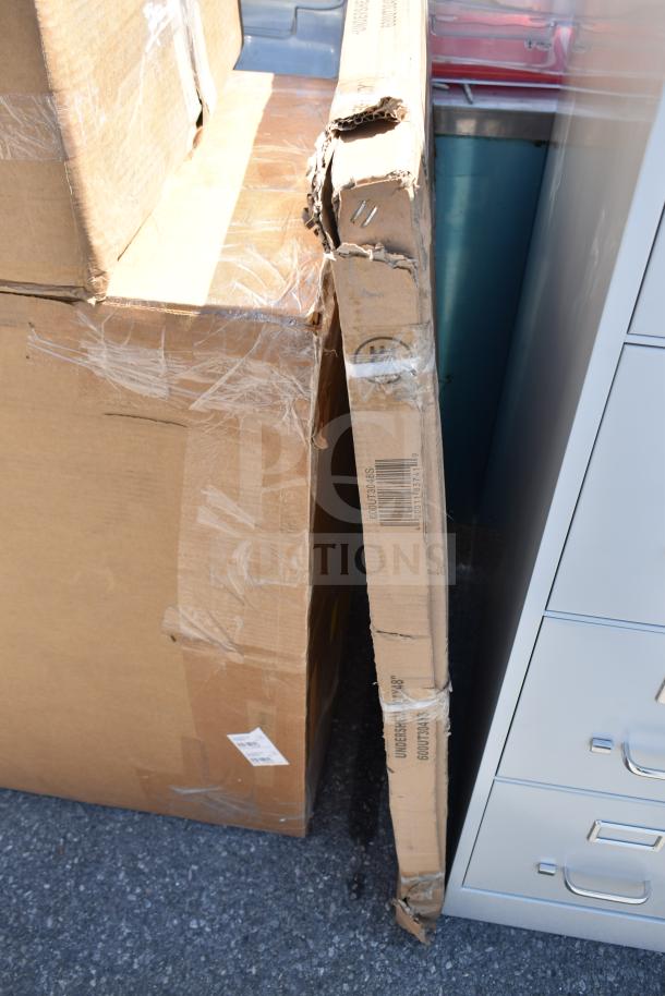 Cardboard boxes labeled "Scratch and Dent" containing new dish and work tables, showing wear and taping.