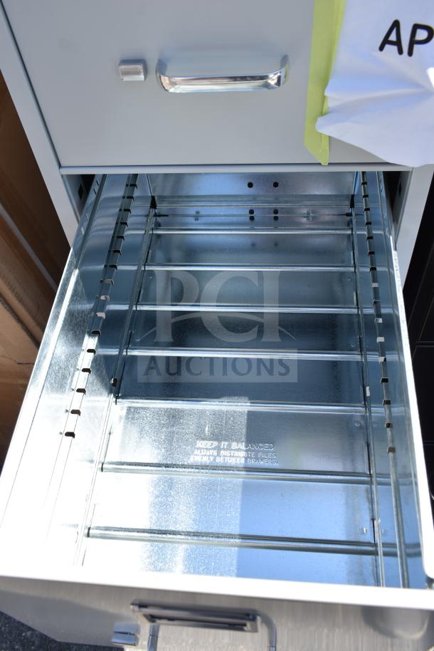 Open drawer of Hirsh 17547 gray four-drawer vertical letter file cabinet. New condition, metal interior visible. Dimensions 15"x25"x52".