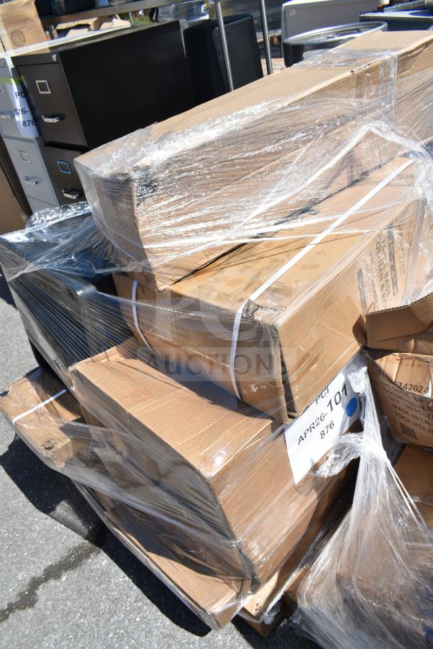 A stack of sealed cardboard boxes labeled APR26-101, containing 8 brand new scratch and dent items including a cart, trash can, and folding table.