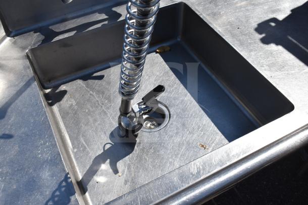 Stainless steel dish table with integrated faucet, featuring clean side and dirty side; visible surface wear.