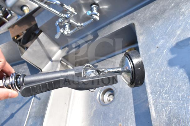 Stainless steel dishwashing setup with pre-rinse spray valve, including clean and dirty side tables. Durable condition.