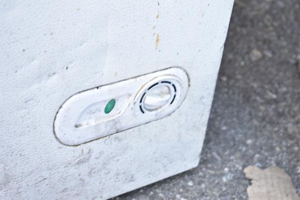 Magic Chef HMCF5W4 chest freezer control panel, showing a used and worn surface with a green indicator light.