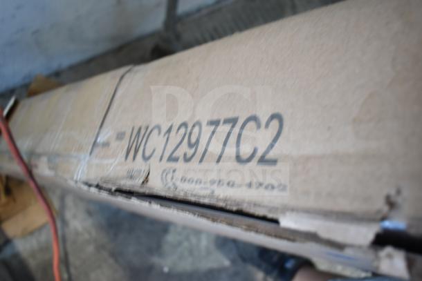 Cardboard box with model number WC12977C2. Condition noted as brand new with scratches and dents visible.