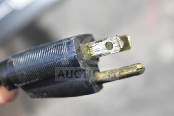 Close-up of a black power plug for a Hobart HTi-7LH26 food portioning scale, showing visible wear and fraying.