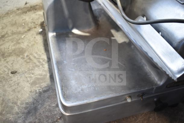 Hobart 1712 commercial meat slicer, stainless steel, 115V, 1 Phase. Shows signs of use on metal surface, switches visible.
