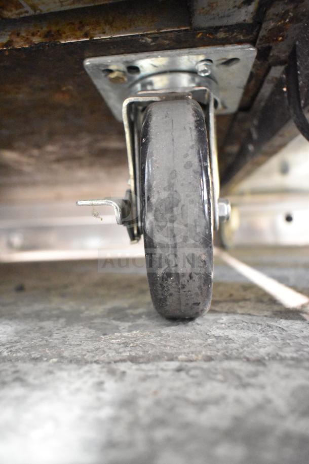 Southbend P48D-BBBB commercial range caster, showing sturdy metal construction and wear, suitable for kitchen mobility.