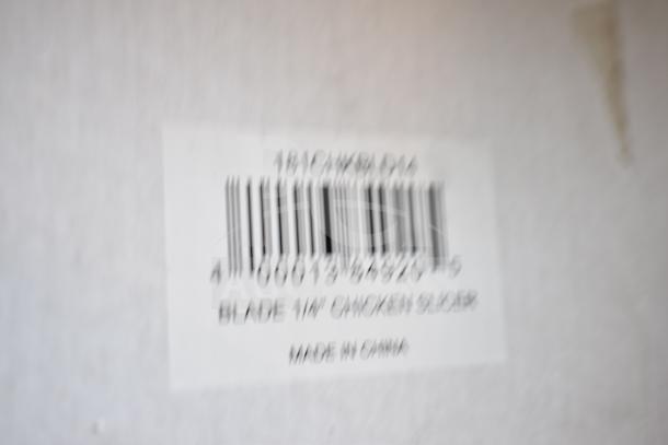 Blurry close-up of a barcode label reading "Garde 181CHKBLD14 Blade 1/4" Chicken Slicer, Made in China."