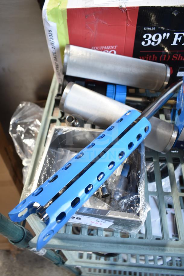 Various new industrial tools on shelf, including a blue metal component and two cylindrical metal parts. Box labeled "39" Frame".