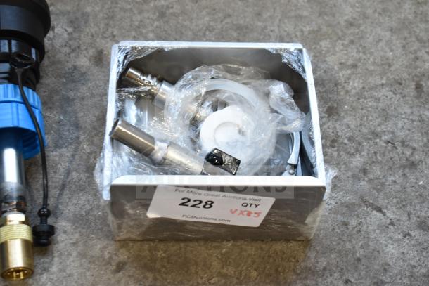 A box of various brand new items, one with blue and brass fittings, labeled "228 QTY VX85" indicating auction details.