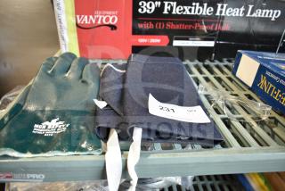 Set of brand new items including a blue apron, green MCR Safety nitrile gloves, and clear safety glasses on a shelf.