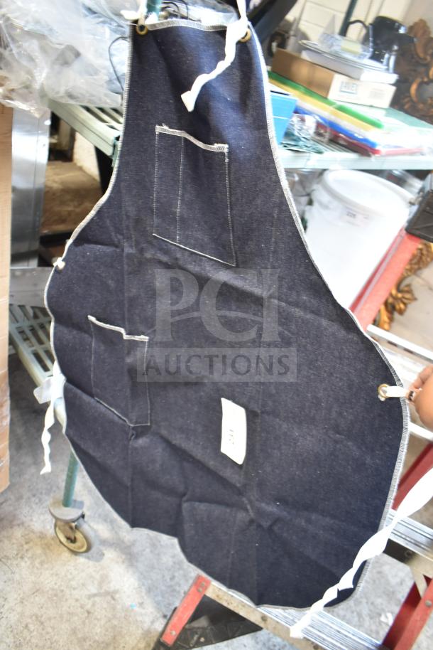 Brand new blue apron with white trim and pockets, slight scratch and dent, includes safety gloves and glasses.