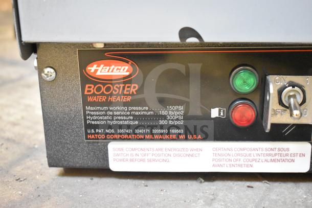 Brand new Hatco C-13 commercial booster water heater. Labels show 150 PSI max working pressure. Includes switches and warning signs.