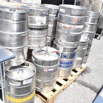 10 assorted metal kegs, including half-size barrels, with visible AB InBev and MicroStar labels, on a pallet.