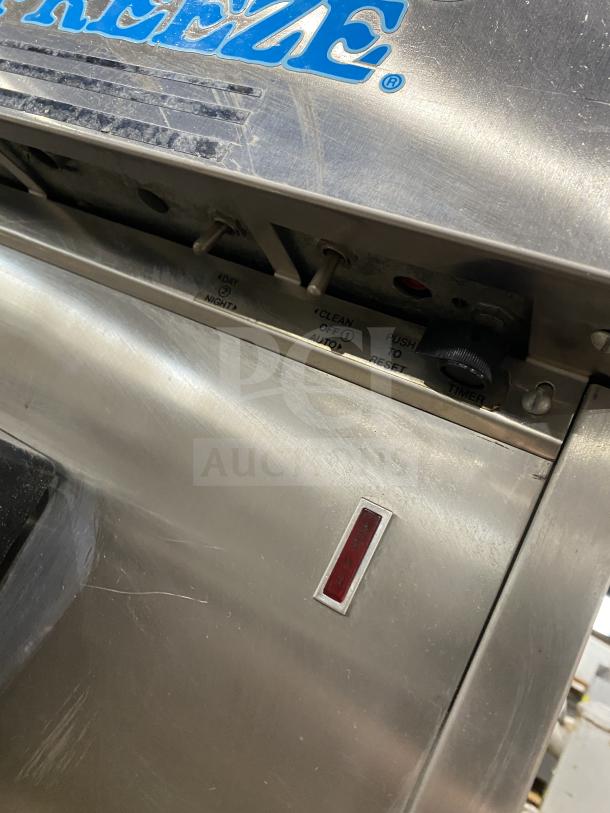 Electro Freeze stainless steel twin/twist soft serve machine, 2 hoppers, 3 dispensers, controls visible, on casters.