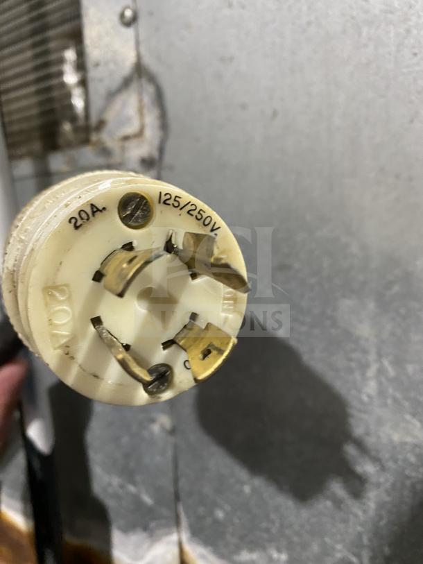 Close-up of a 20A, 125/250V plug on a Hoshizaki ice machine, Model KM-515MAH, showing prongs and label.