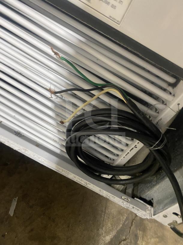 Stainless steel ice cream dipping cabinet with curved glass, rear lift-open access, and exposed wiring beneath, pre-owned condition.