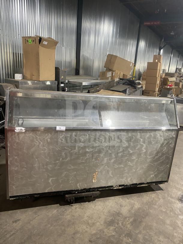 Commercial stainless steel ice cream/frozen yogurt cabinet with slanted glass and rear lift-open access. Some wear visible.