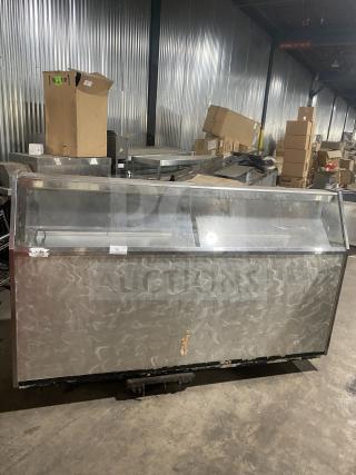 Commercial stainless steel ice cream/frozen yogurt cabinet with slanted glass and rear lift-open access. Some wear visible.
