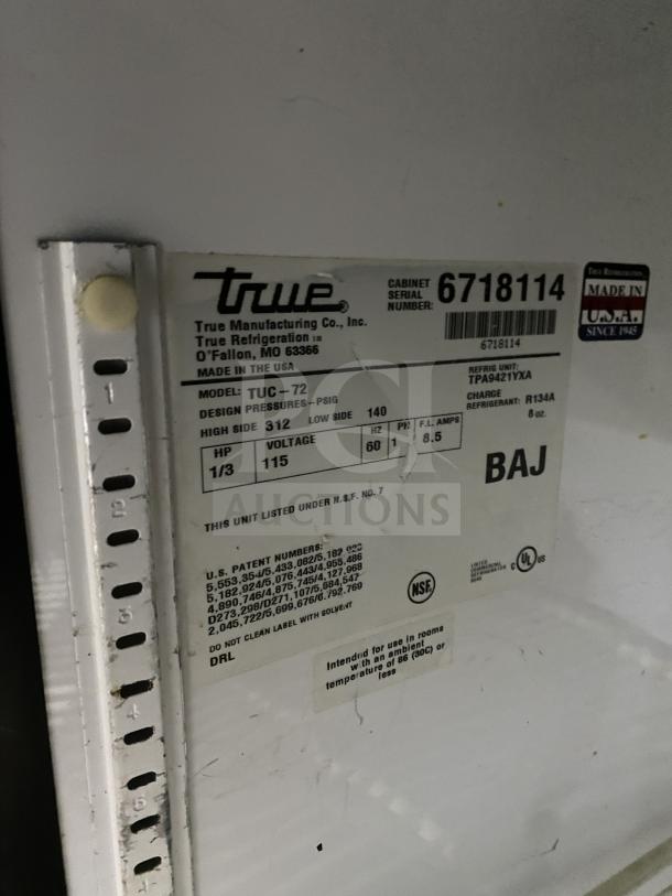 True TUC-72 commercial 3-door stainless steel undercounter refrigerator on casters. Features poly-coated wire rack. Serial: 6718114.