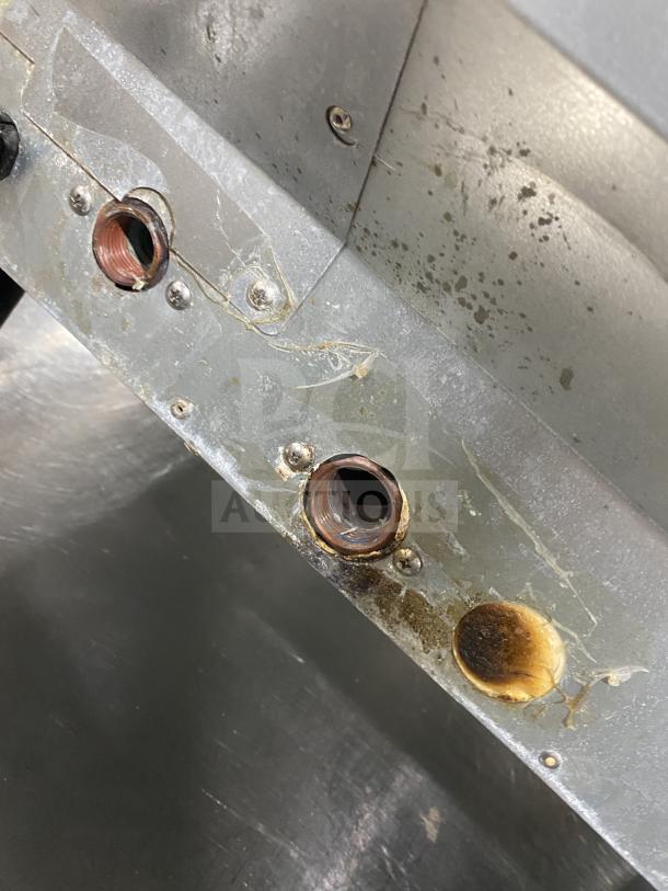 Close-up of rusted components on a Hoshizaki KM231BAJ ice machine. Signs of wear and usage visible on a stainless steel surface.