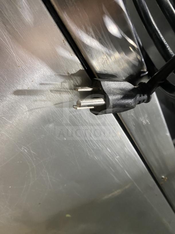 Close-up of power plug against stainless steel surface of Hoshizaki KM231BAJ ice machine, showing texture and condition.