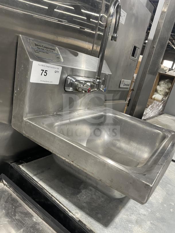 Jimex stainless steel wall-mount hand sink, commercial-grade, with backsplash. Includes dual faucets. Slight wear visible.