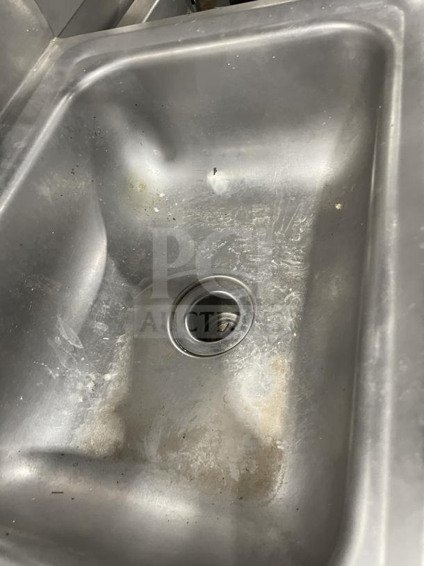 Jimex commercial stainless steel wall-mount hand sink with backsplash, fair condition. Signs of use, sturdy design.