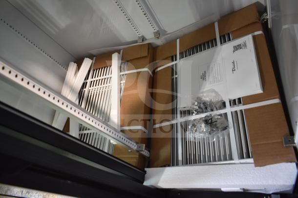 Brand new 2025 True GDM-33-HC-LD reach-in cooler interior, shelves packaged with protective materials, includes assembly hardware.