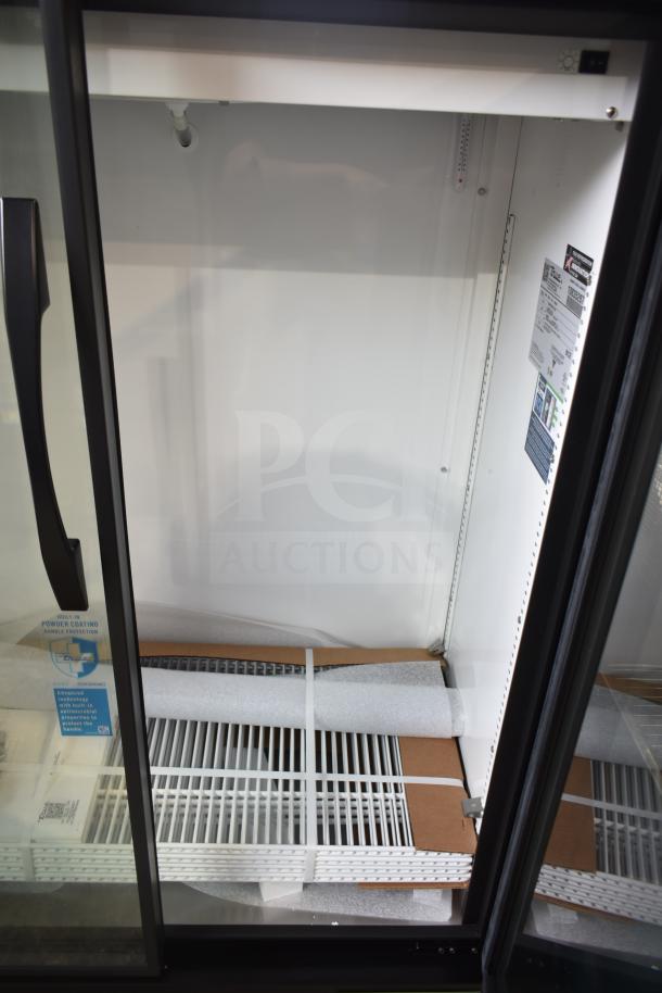 Brand new 2024 True TVM-36SL-HC commercial 2-door cooler. Scratch and dent condition, 115V, 1 phase. Tags indicate model details.