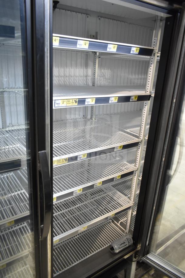 2019 True GDM-72F-HC commercial 3-door reach-in freezer merchandiser, black frame, glass doors, shelves with price labels.