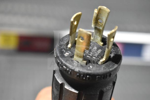 Close-up of a power plug for the 2017 True GDM-72F-HC commercial freezer, showing metal prongs and a black casing.