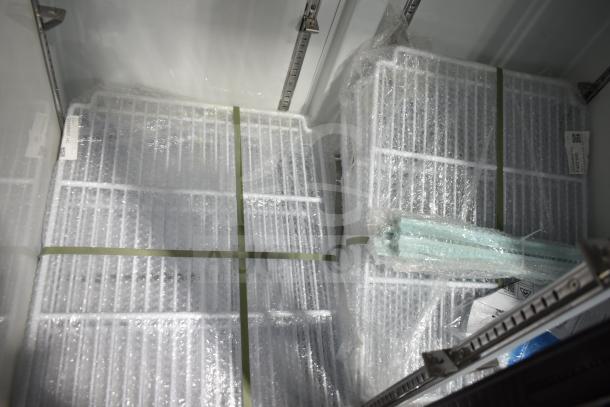 Brand new Avantco 178GDS33HCB fridge shelves wrapped in bubble wrap, inside sliding glass door merchandiser.