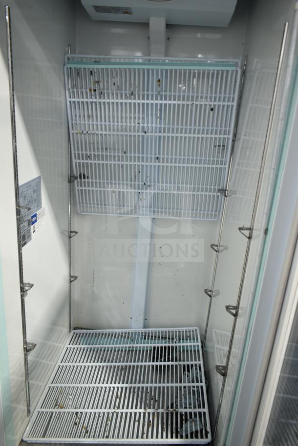 Brand new Avantco 178GDC24FHCW glass door merchandiser freezer, white, with LED lighting and shelving. Scratch and dent condition.