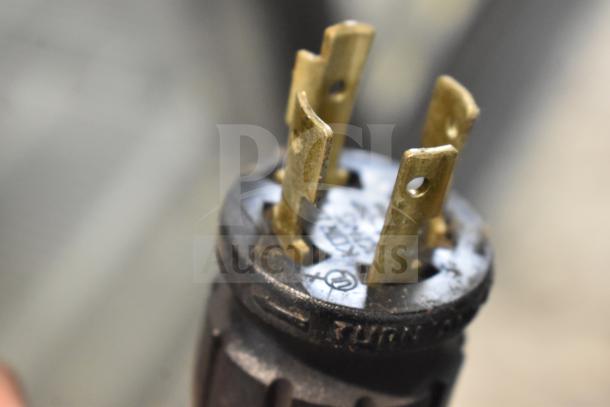 Close-up of a plug for the 2017 True GDM-72F-HC commercial freezer. Features brass prongs, indicative of a robust electrical connection.