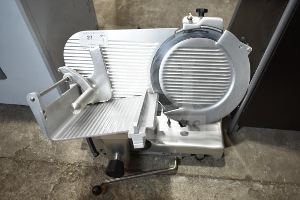 Brand new Estella 348SLM13 manual meat slicer, 13" blade, 1/2 hp, includes blade sharpener, minor scratches visible.