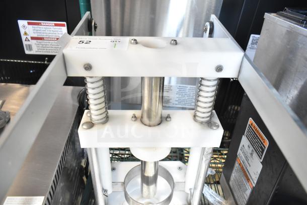 Countertop pineapple corer with metal springs and frame, near-new condition. Tags show item number 52 and safety warnings.